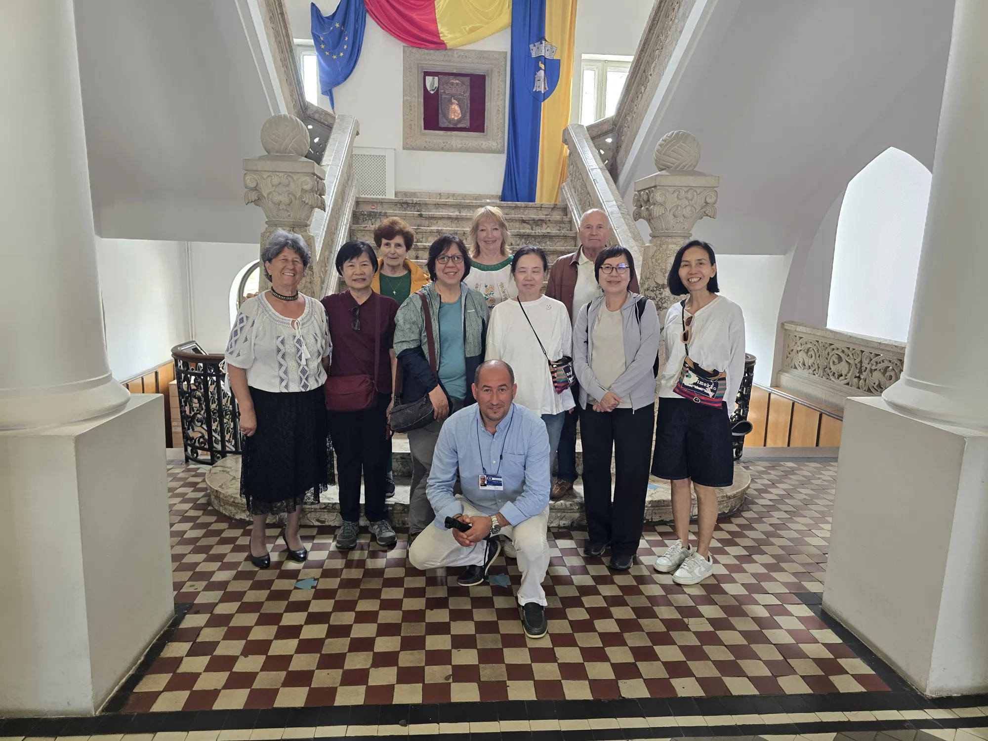 Nick, our founder and guide, with a group of travellers in a hall decorated with Romanian flags