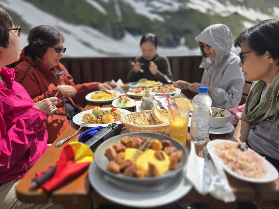 Lunch on the terrace at Bâlea Lake, with mountains and snow beyond