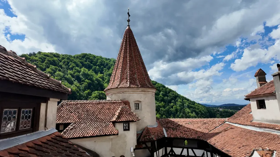 Red roofs and a tower of Bran Castle, with the valley beyond