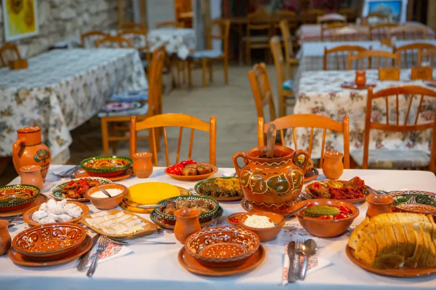 A table laid with traditional Romanian dishes in painted ceramic bowls