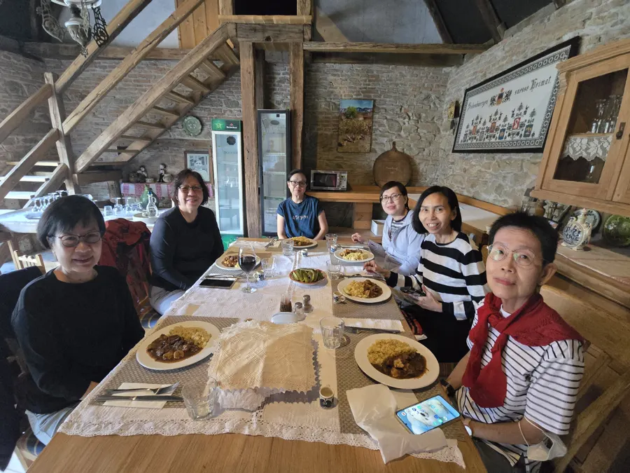 A long table of travellers sharing dinner in a restaurant in Viscri
