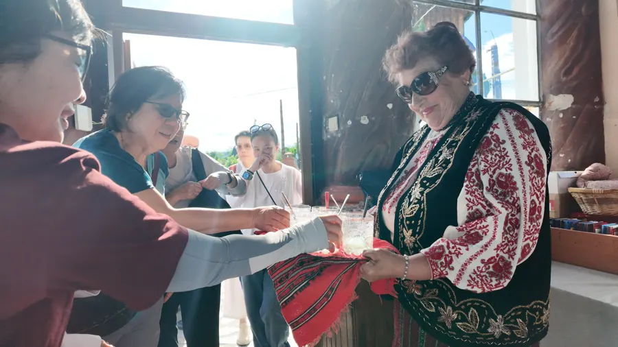 A host in traditional dress welcomes guests with bread and salt