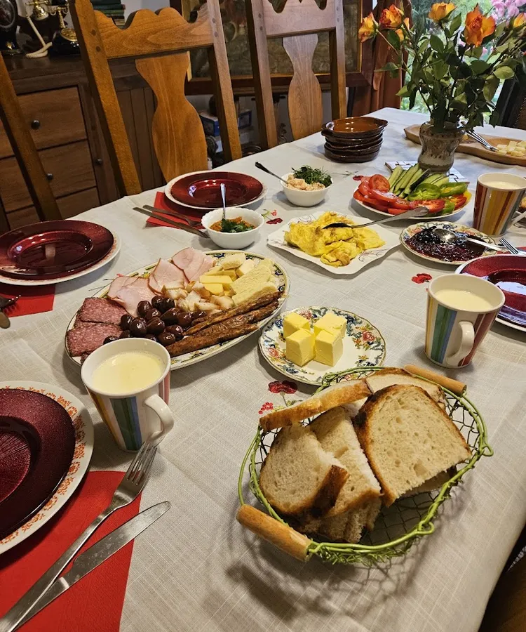 A long table set for a winery lunch with cold cuts, cheese, bread and flowers